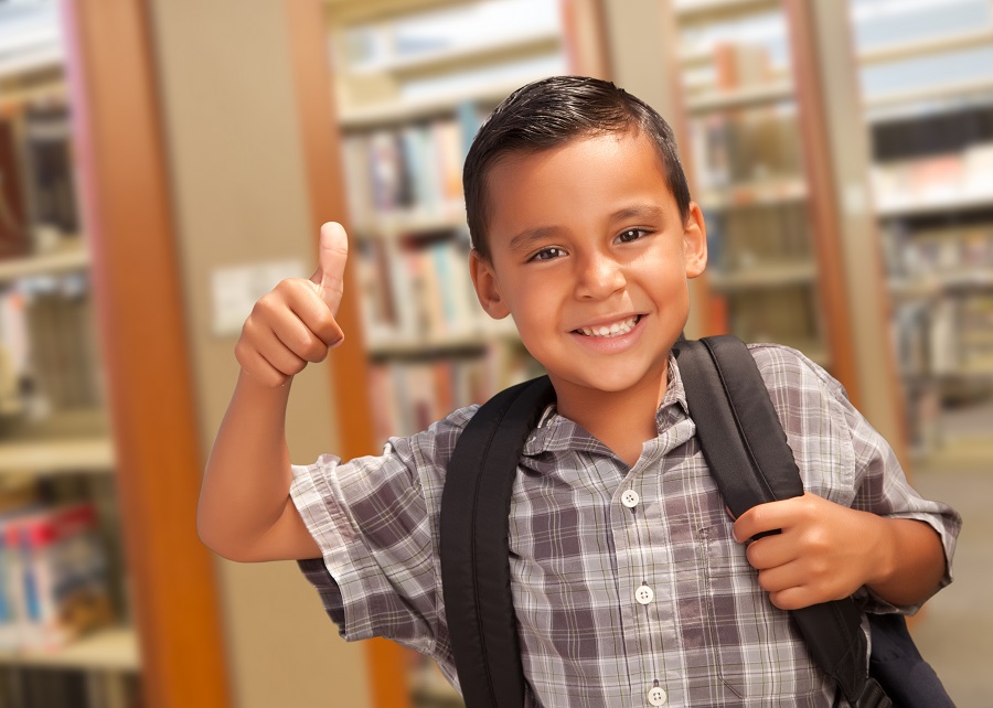 Smiling Latino Boy Giving Thumbs Up in Library